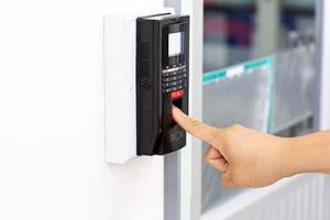 Pessoa utilizando leitor biométrico com teclado numérico instalado na parede para automação predial
