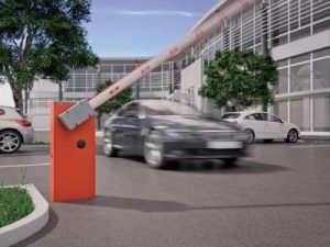 Cancela automática na cor laranja levantada com veículo passando por área de acesso controlado